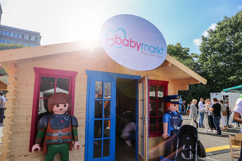 Playmobil Holzhütte mit babymarkt.de Logo